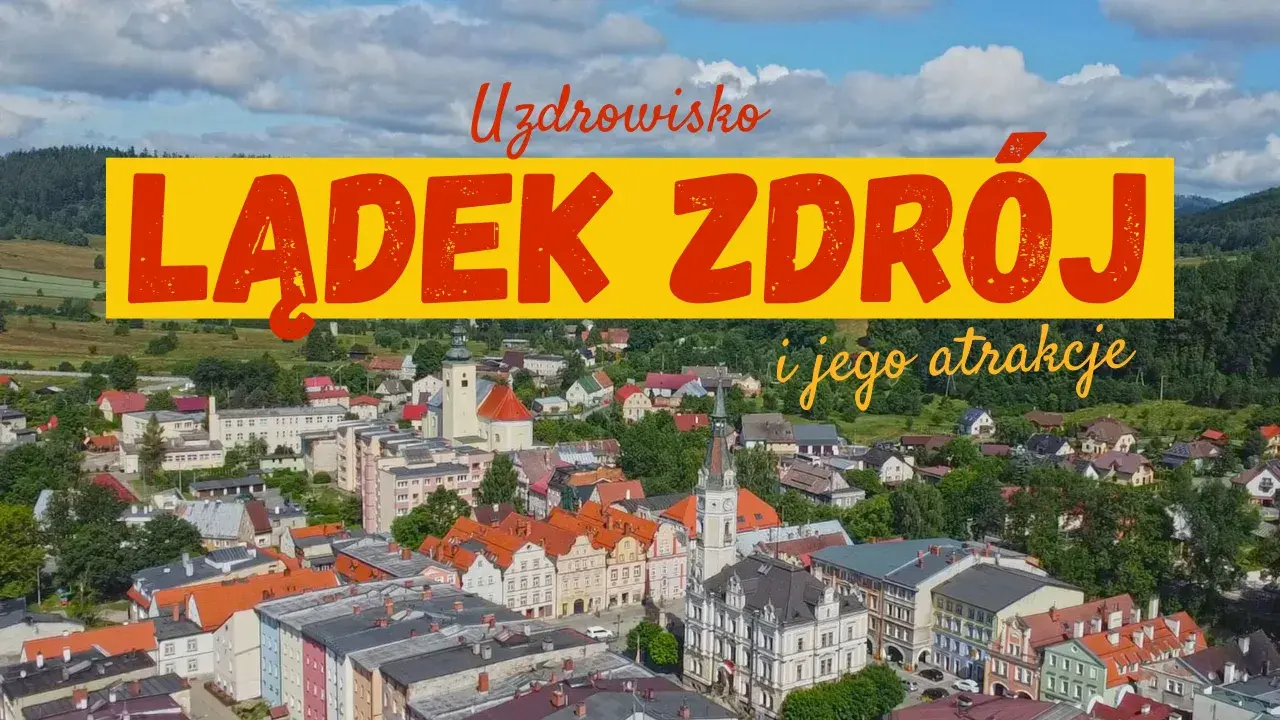 Widok na Lądek Zdrój i jego atrakcje. Miasto z kolorowymi kamienicami, kościołem i zielonymi wzgórzami w tle.