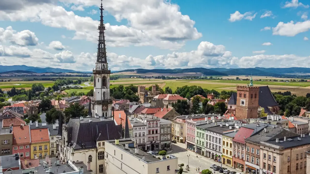 Widok na rynek i wieżę ratuszową w Ząbkowicach Śląskich. Kolorowe kamienice i zamek tworzą piękne ząbkowice śląskie atrakcje.