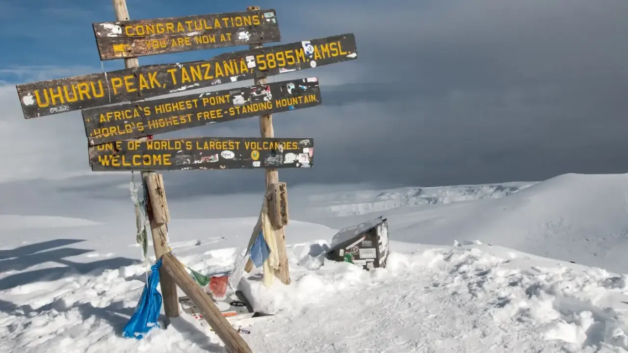 Snieg w Afryce na szczycie Uhuru Peak, Tanzania. Znaki informują o wysokości 5895 m n.p.m. i o tym, że to najwyższy punkt Afryki.
