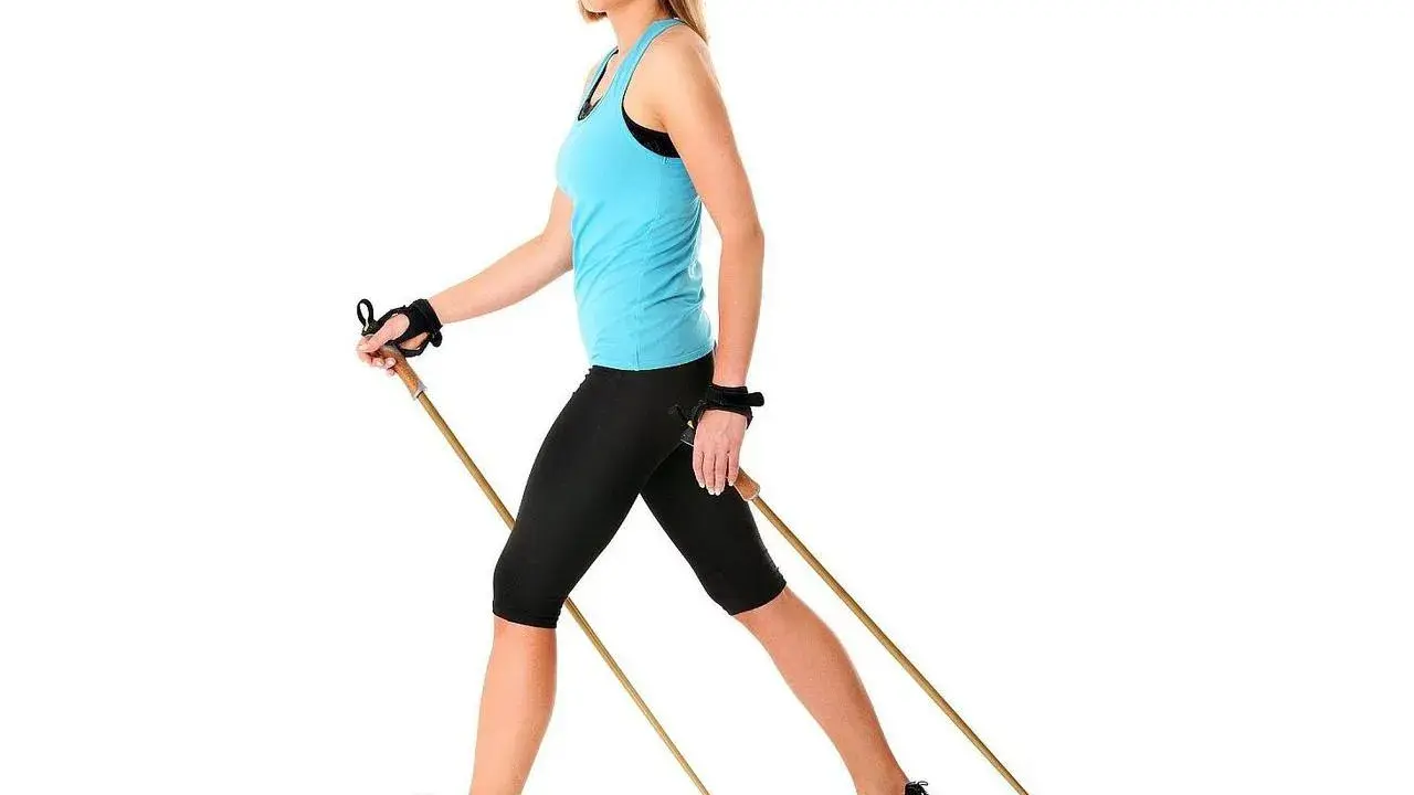 Kobieta z kijami do nordic walking, idealne do ćwiczeń. Dowiedz się, jak dobrać kije do nordic walking, by czerpać z nich maksimum korzyści.