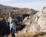 Kobieta w okularach fotochromowych wędruje po skalistym terenie.