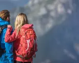 Para w górach, ona w czerwonym, on w niebieskim, oboje z plecakami. Jaki plecak w góry wybrać?