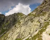 Kamienista ścieżka wije się po zboczu górskim. Szpiglasowy Wierch zaprasza na trudną, ale piękną trasę.