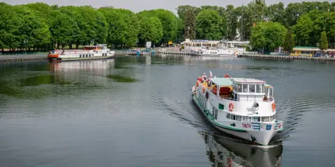 Rejs po jeziorze w Giżycku to jedna z głównych atrakcji. Statek "Tałty" płynie w stronę portu, gdzie cumują inne jednostki.