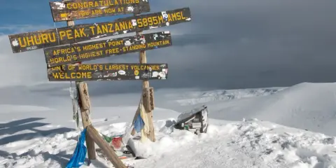 Snieg w Afryce na szczycie Uhuru Peak, Tanzania. Znaki informują o wysokości 5895 m n.p.m. i o tym, że to najwyższy punkt Afryki.