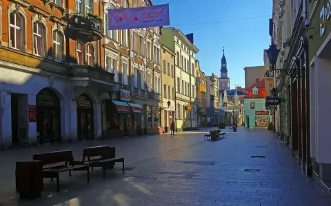 Spacer po urokliwym rynku w Lesznie. Kolorowe kamienice, sklepiki i wieża ratusza tworzą piękne leszno atrakcje.