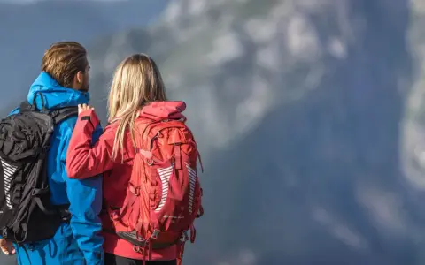 Para w górach, ona w czerwonym, on w niebieskim, oboje z plecakami. Jaki plecak w góry wybrać?