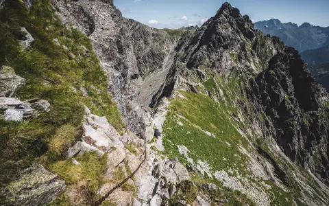 Wąska ścieżka z łańcuchami na skraju orlej perci, prowadząca przez skaliste zbocza Tatr.