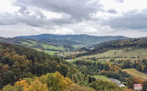 Jesienny krajobraz Gór Sowich z kolorowymi drzewami i pagórkami.