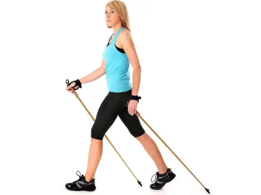 Kobieta z kijami do nordic walking, idealne do ćwiczeń. Dowiedz się, jak dobrać kije do nordic walking, by czerpać z nich maksimum korzyści.