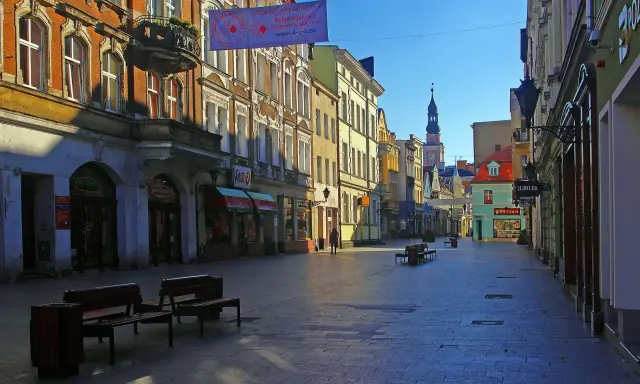 Spacer po urokliwym rynku w Lesznie. Kolorowe kamienice, sklepiki i wieża ratusza tworzą piękne leszno atrakcje.