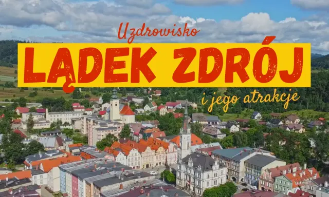 Widok na Lądek Zdrój i jego atrakcje. Miasto z kolorowymi kamienicami, kościołem i zielonymi wzgórzami w tle.