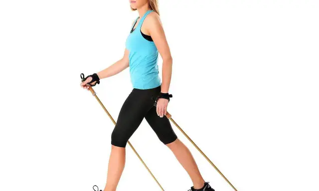 Kobieta z kijami do nordic walking, idealne do ćwiczeń. Dowiedz się, jak dobrać kije do nordic walking, by czerpać z nich maksimum korzyści.