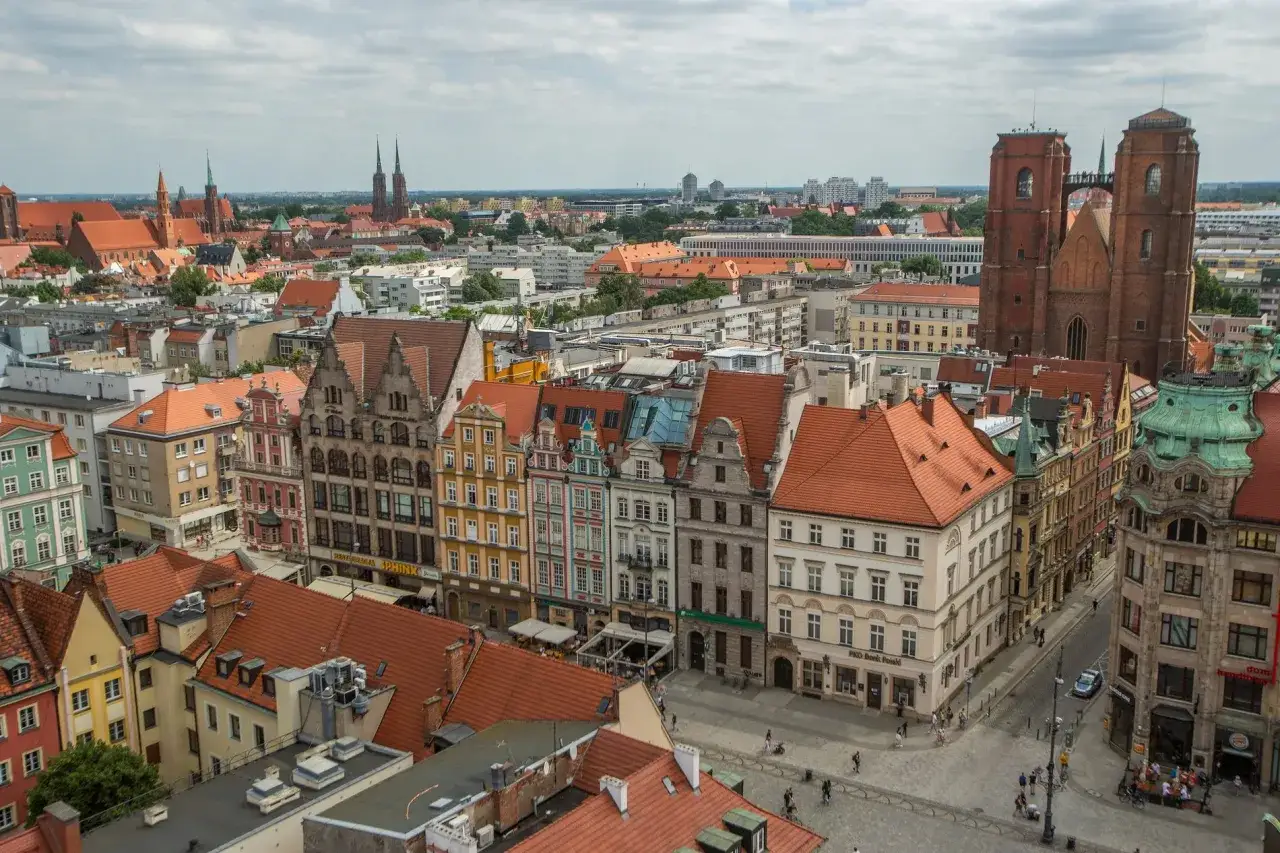 Widok na wrocławski Rynek z kolorowymi kamienicami i katedrą. Idealne miejsce, by zobaczyć, co zwiedzić we Wrocławiu.