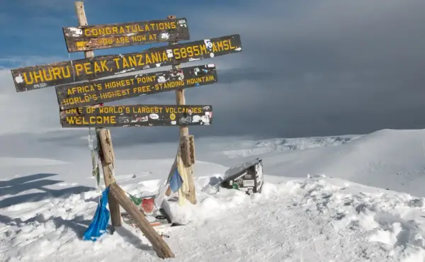 Snieg w Afryce na szczycie Uhuru Peak, Tanzania. Znaki informują o wysokości 5895 m n.p.m. i o tym, że to najwyższy punkt Afryki.